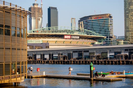 pexels photo 18510083 18510083 Marvel Stadium seen from the waterfront in Melbourne with city skyline, offering urban and travel vibes.